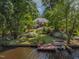 Backyard view of a home with a wood dock, boat, and beautiful landscaping at 959 Sagamore Dr, Louisburg, NC 27549