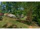 Picturesque backyard with vibrant landscaping, mature trees, and waterfront views at 959 Sagamore Dr, Louisburg, NC 27549