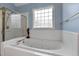 Close up of jetted bathtub featuring shower with glass block window above at 959 Sagamore Dr, Louisburg, NC 27549