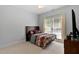Cozy bedroom with patterned bedding, a ceiling fan, and a large window for natural light at 959 Sagamore Dr, Louisburg, NC 27549