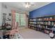 Well-lit bedroom with a blue accent wall, a bookshelf, and a comfortable workspace at 959 Sagamore Dr, Louisburg, NC 27549