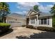 Side view showing a two-car garage and a neatly landscaped yard with mature plantings at 959 Sagamore Dr, Louisburg, NC 27549