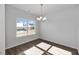 Bright dining room featuring wood flooring, a modern chandelier, and a large window for natural light at 4868 Pioneer Dr, Sanford, NC 27330