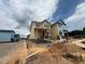 New homes under construction with yellow siding and brick foundations under a cloudy sky at 10 Relaxing Way, Pittsboro, NC 27312