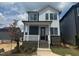 Charming two-story home showcasing a brick foundation, covered porch, and modern architectural design at 10 Relaxing Way, Pittsboro, NC 27312