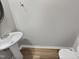Powder room with pedestal sink and wood-look flooring, offering a modern touch at 10 Sandy Bluff Ct, Durham, NC 27703