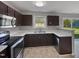 Modern kitchen with stainless steel appliances, dark cabinetry, and bright countertops at 10 Sandy Bluff Ct, Durham, NC 27703