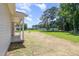 Expansive backyard featuring green grass, mature trees, and a covered patio for outdoor enjoyment at 1000 Peedin Rd, Selma, NC 27576