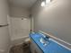 A full bathroom with a shower and a vanity sink featuring blue countertops at 1000 Peedin Rd, Selma, NC 27576
