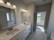 Bright bathroom with dual sinks, a large mirror, modern lighting, and a separate shower at 1000 Peedin Rd, Selma, NC 27576