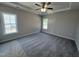 Spacious bedroom with plush carpet, a ceiling fan, and two windows for natural light at 1000 Peedin Rd, Selma, NC 27576