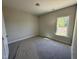 A cozy bedroom featuring neutral walls, carpet floors, and a window providing natural light at 1000 Peedin Rd, Selma, NC 27576