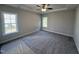 Neutral bedroom boasts two windows, plush carpeting, and a ceiling fan at 1000 Peedin Rd, Selma, NC 27576