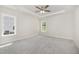 Bright bedroom with neutral carpet, ceiling fan, tray ceiling, and natural light from two windows at 1000 Peedin Rd, Selma, NC 27576