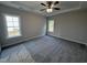 Spacious bedroom featuring plush carpeting, a ceiling fan, and ample natural light from two windows at 1000 Peedin Rd, Selma, NC 27576