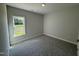 Neutral bedroom with gray carpeting and a window overlooking a field at 1000 Peedin Rd, Selma, NC 27576