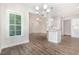 Open dining room area with modern chandelier, luxury vinyl flooring, and connecting access to kitchen and living room at 1000 Peedin Rd, Selma, NC 27576