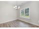 Bright dining area with luxury vinyl floors, a window, and modern chandelier lighting at 1000 Peedin Rd, Selma, NC 27576