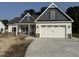 Charming home featuring a two-car garage, gray accents, a manicured lawn, and a welcoming entrance at 1000 Peedin Rd, Selma, NC 27576
