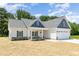 Charming single-Gathering home featuring a covered front porch, landscaped yard, and attached garage at 1000 Peedin Rd, Selma, NC 27576