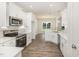 Open kitchen with stainless appliances, white cabinets, stylish backsplash, and an island, perfect for entertaining at 1000 Peedin Rd, Selma, NC 27576