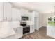 Bright kitchen features stainless steel appliances, white cabinets, quartz countertops, and stylish backsplash at 1000 Peedin Rd, Selma, NC 27576