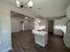 Open-concept kitchen with hardwood floors, white cabinets, modern appliances, and an island sink at 1000 Peedin Rd, Selma, NC 27576