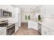 Bright kitchen featuring stainless appliances, white cabinetry, decorative backsplash, and wood-look flooring at 1000 Peedin Rd, Selma, NC 27576