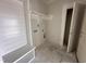 A bright, unfinished laundry room with white cabinets, shelves, and access to the utility connections at 1000 Peedin Rd, Selma, NC 27576
