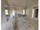 Spacious living room with a cozy fireplace, bathed in natural light from the surrounding windows at 1000 Peedin Rd, Selma, NC 27576