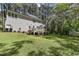 Expansive backyard view showing a large lawn, deck, and shed, set against a backdrop of mature trees, for outdoor enjoyment at 1013 Whitney Springs Ct, Holly Springs, NC 27540
