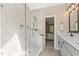 Modern tiled shower with glass door is adjacent to a vanity with light gray cabinets at 1013 Whitney Springs Ct, Holly Springs, NC 27540