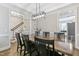 Elegant dining room featuring a large wooden table, modern lighting, and easy access to other living spaces at 1013 Whitney Springs Ct, Holly Springs, NC 27540