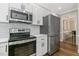Modern kitchen with stainless steel appliances, white cabinets, and a sleek design, perfect for cooking and entertaining at 1013 Whitney Springs Ct, Holly Springs, NC 27540