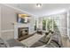 Cozy living room featuring a fireplace, large windows, and comfortable seating for a relaxing atmosphere at 1013 Whitney Springs Ct, Holly Springs, NC 27540