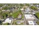 An aerial shot shows a serene neighborhood with a church, various buildings, and lush green trees at 104 E Wilson St, Mebane, NC 27302