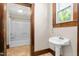 A half-bathroom is shown, with a pedestal sink and a view into the full bathroom at 104 E Wilson St, Mebane, NC 27302