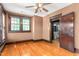 Bedroom with wood floors, ceiling fan, wood trim, and access to bathroom at 104 E Wilson St, Mebane, NC 27302