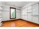 Walk-in closet with white shelving units and hardwood floors at 104 E Wilson St, Mebane, NC 27302