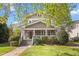 Charming two-story home with a welcoming front porch and well-maintained landscaping on a sunny day at 104 E Wilson St, Mebane, NC 27302