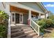 Inviting front porch with wood ceiling, white columns and railing, and security system at 104 E Wilson St, Mebane, NC 27302