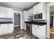 Efficient kitchen featuring stainless steel appliances, black countertop and checkerboard floors at 104 E Wilson St, Mebane, NC 27302