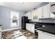 Open kitchen with large windows for great natural light, black appliances, and ample cabinet space at 104 E Wilson St, Mebane, NC 27302