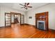 Spacious living room featuring hardwood floors, decorative wood trim, ceiling fan, and fireplace at 104 E Wilson St, Mebane, NC 27302