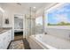Bright bathroom features a glass-enclosed shower, soaking tub with jets, and access to bedroom at 1093 Trentini Ave, Wake Forest, NC 27587