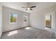 Sunlit bedroom with neutral walls and carpet, featuring two windows and a glimpse of a walk-in closet at 1093 Trentini Ave, Wake Forest, NC 27587