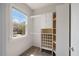 Bright walk-in closet with custom shelving and a window with a glimpse of a neighboring home at 1093 Trentini Ave, Wake Forest, NC 27587