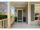 Welcoming covered front porch featuring an inviting dark green front door and decorative potted plants at 1093 Trentini Ave, Wake Forest, NC 27587