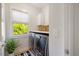 Modern laundry room with front load washer and dryer and natural light from a window with leafy trees outside at 1093 Trentini Ave, Wake Forest, NC 27587