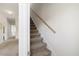 Carpeted stairway with a wooden handrail and freshly painted walls at 1093 Trentini Ave, Wake Forest, NC 27587